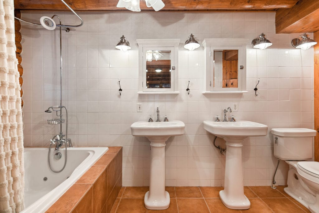 The master bathroom showing two pedestal sinks and whirlpool tub
