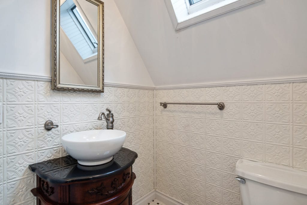 Powder room with tile surround and floating sink vanity