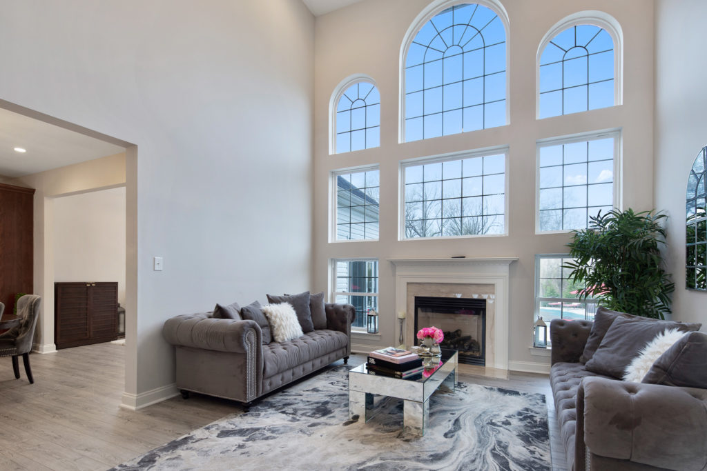 Family room has wall of windows surrounding the fireplace mantle.