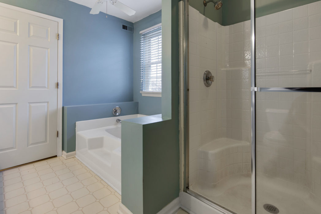 Stall shower has two seats and glass sliding door